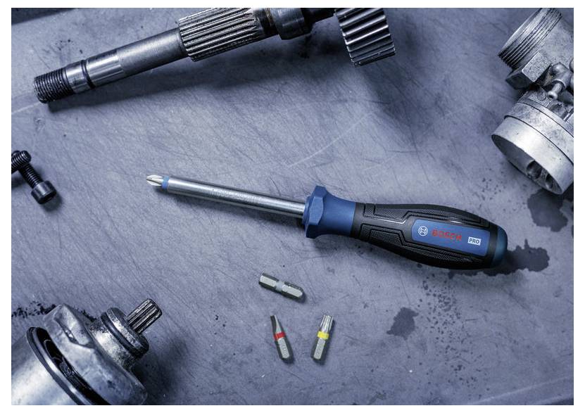 Bosch skruvdragarbits på en metallarbetsbänk omgiven av industriella maskindelar och flera skruvdragarbit.