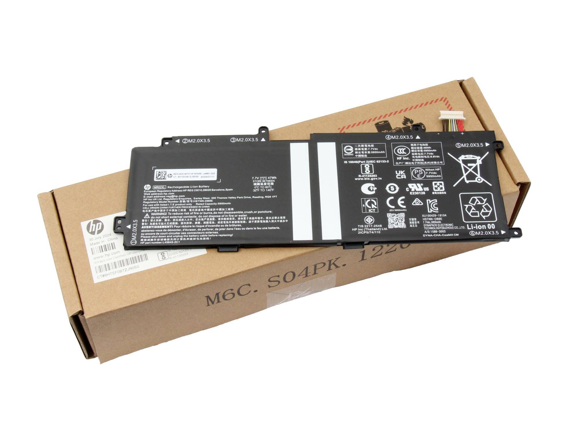 Bärbar datorns batterisats på en kartongbox, med synlig HP-förpackning och certifieringsetiketter.