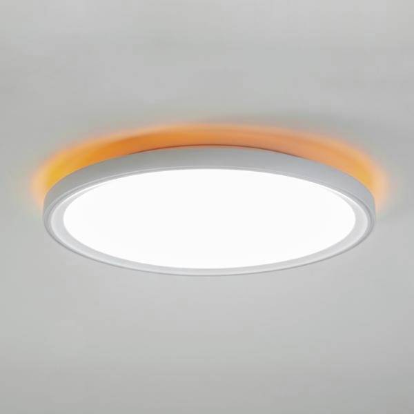 Rund vit taklampa med en mjuk orange glöd runt kanten på ett grått tak.