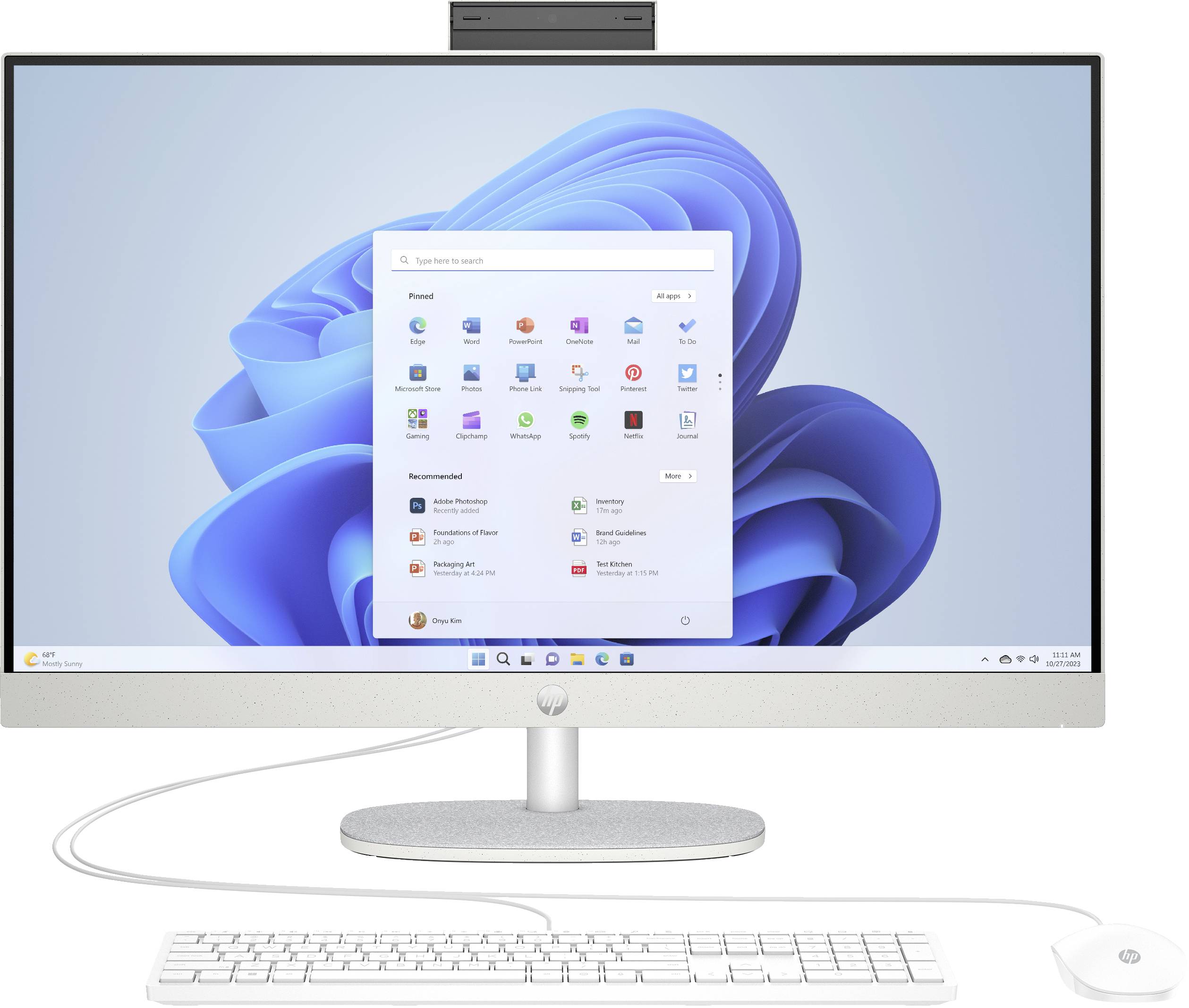 Skrivbordsdatoruppsättning som visar en HP-skärm med Windows 11-startmenyn öppen, plus matchande tangentbord och mus på vit bakgrund.