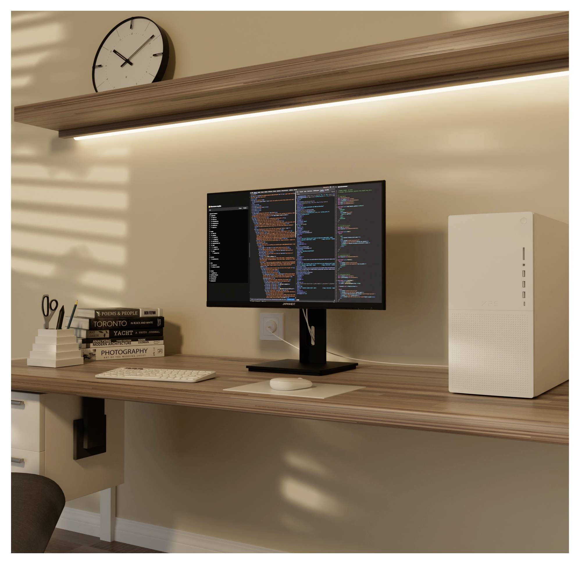 Minimalt hemmakontor med skrivbord med väggmonterad skärm som visar kod, tangentbord, mus, böcker, sax och ett vitt PC-chassi under en klockskyllapy.