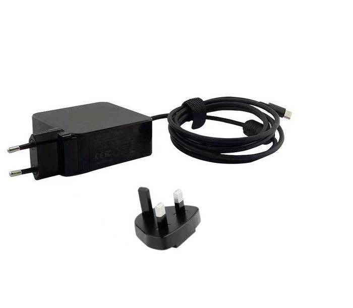 Svart väggadapter med tvåstiftsuttag, ansluten USB-kabel och avtagbar brittisk tresstiftskontakt visad mot vit bakgrund.