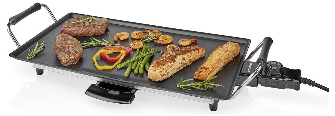 Elektrisk bordsgrill med blandade tillagade köttsörter, räkor, sparris, paprikor och örter på en svart stekyta.