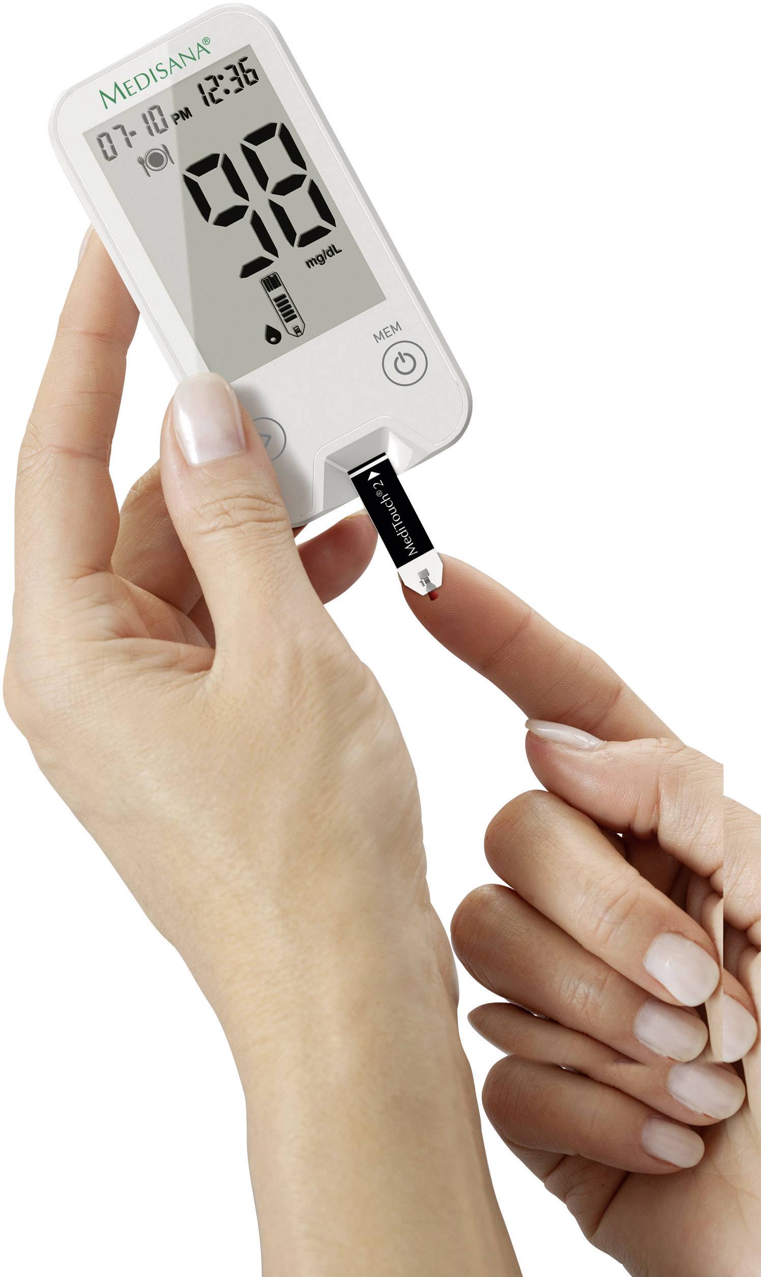 En hand håller ett blodsockermätningsverktyg från Medisana, medan ett finger trycks mot teststrimlan.