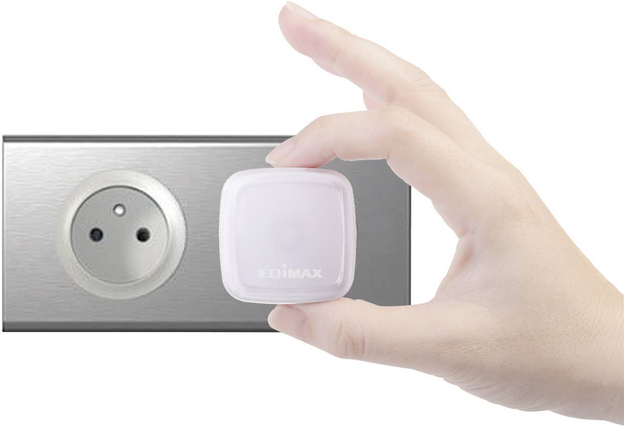 En hand håller en liten, fyrkantig sensor framför ett eluttag; symbol för teknik eller smarta hemenheter.