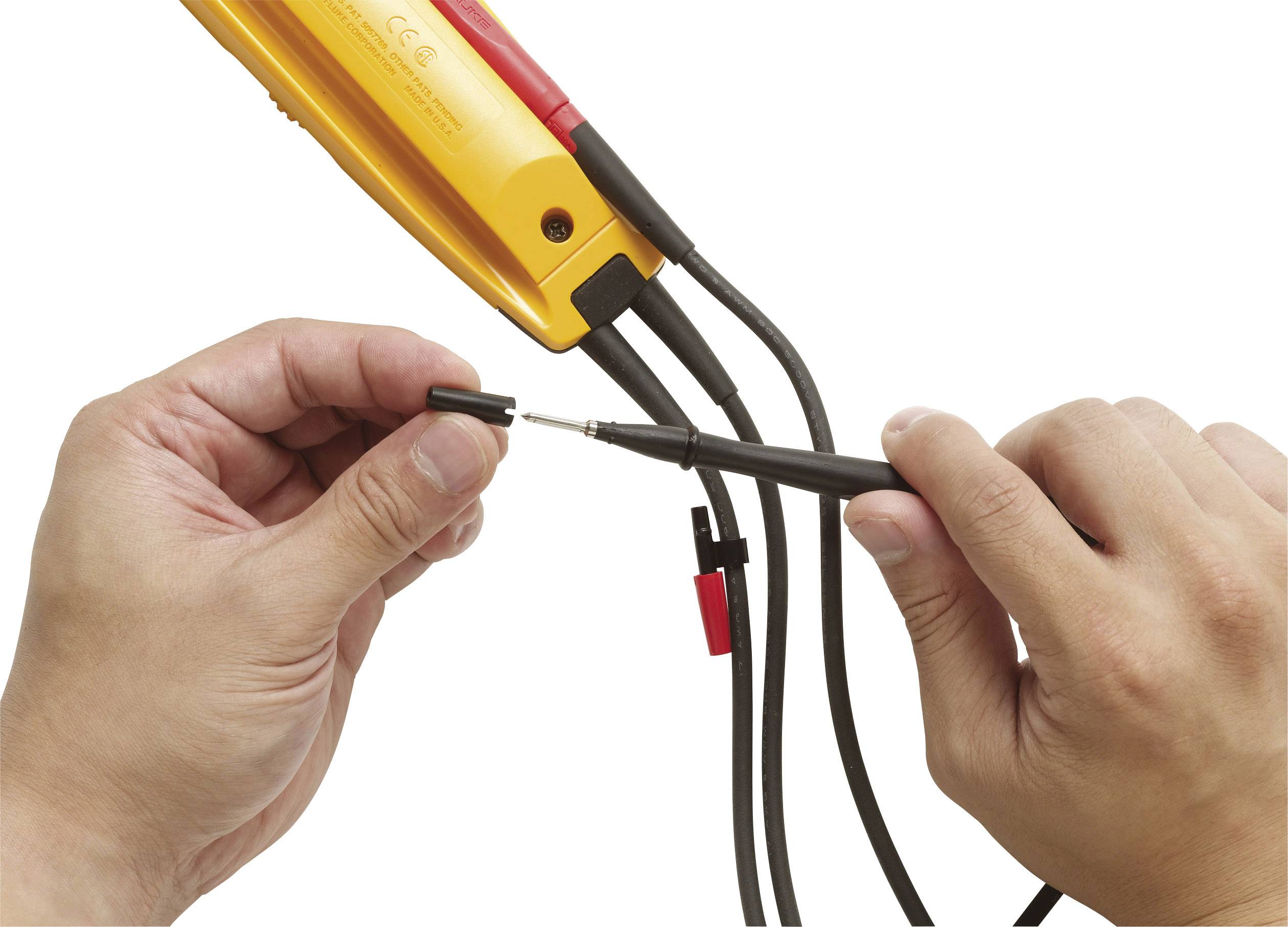 En person håller ett elektriskt mätinstrument och ansluter kablar med en mätpunkt för att mäta spänningen.