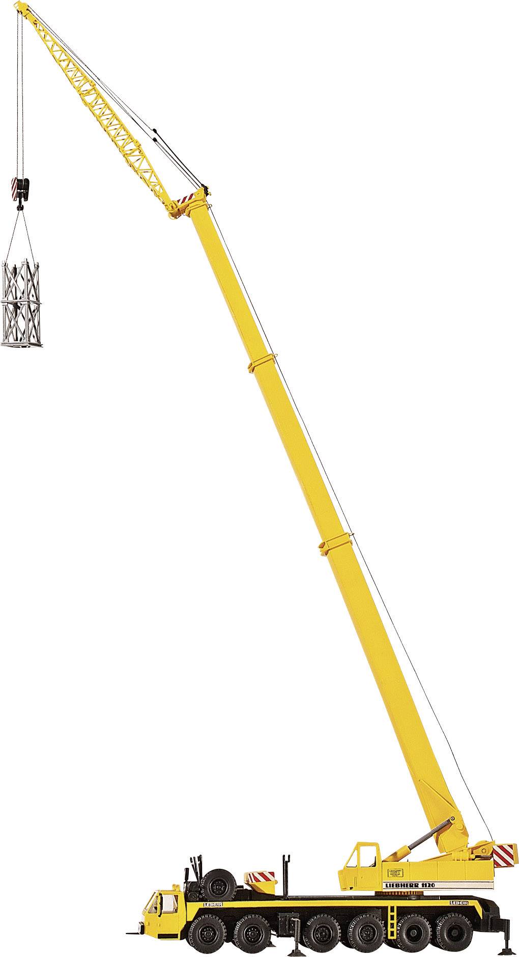 En gul mobilkran lyfter en stålställning högt upp i luften. Kranen har en lång bom och står på sex hjul.