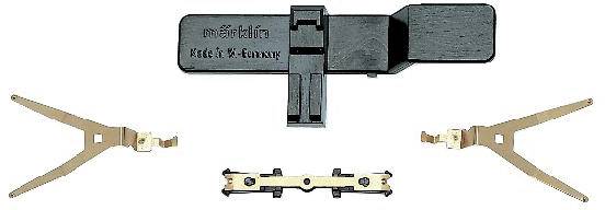 En svart, rektangulär modelljärnvägskopplingsavlänkare med påskriften 'märklin' och 'Made in W.-Germany' samt tre beige metalldelar.