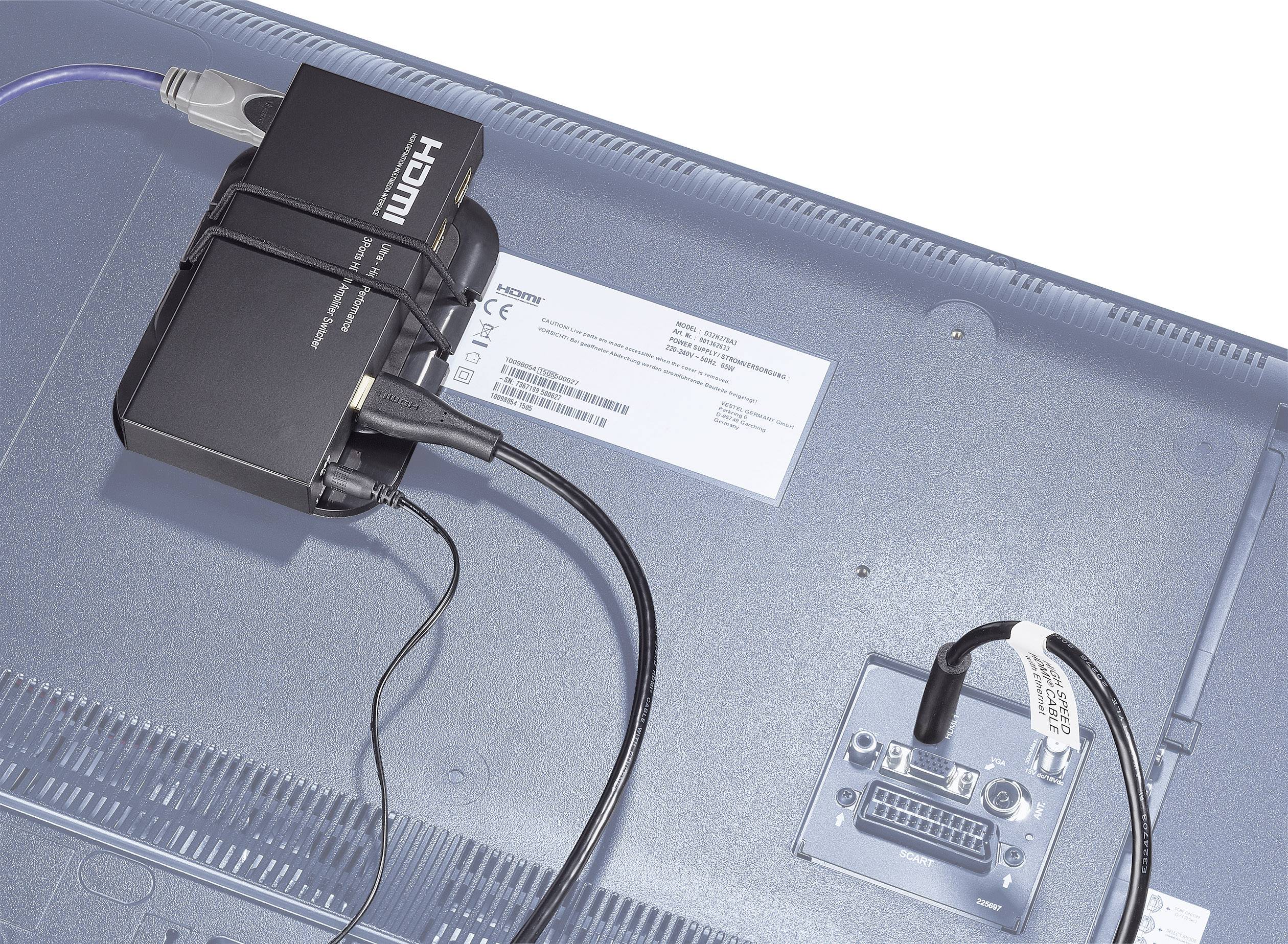 En svart HDMI-konverterare är ansluten till HDMI-porten på baksidan av en skärm. Kablar leder bort från konverteraren.