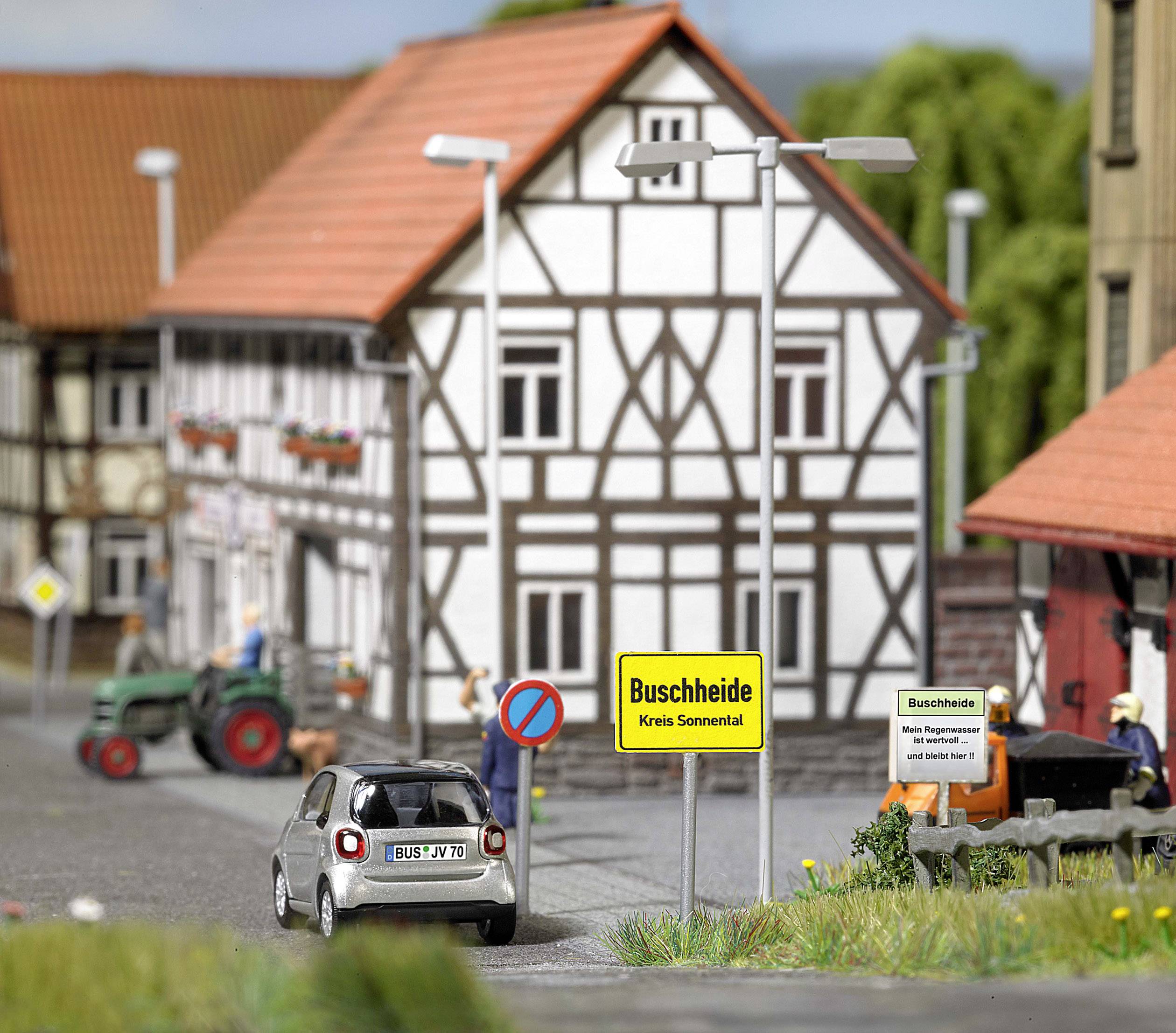 Miniutställning av en tysk by med korsvirkeshus. I förgrunden kör en bil förbi en vägskyllt med texten "Buschheide".