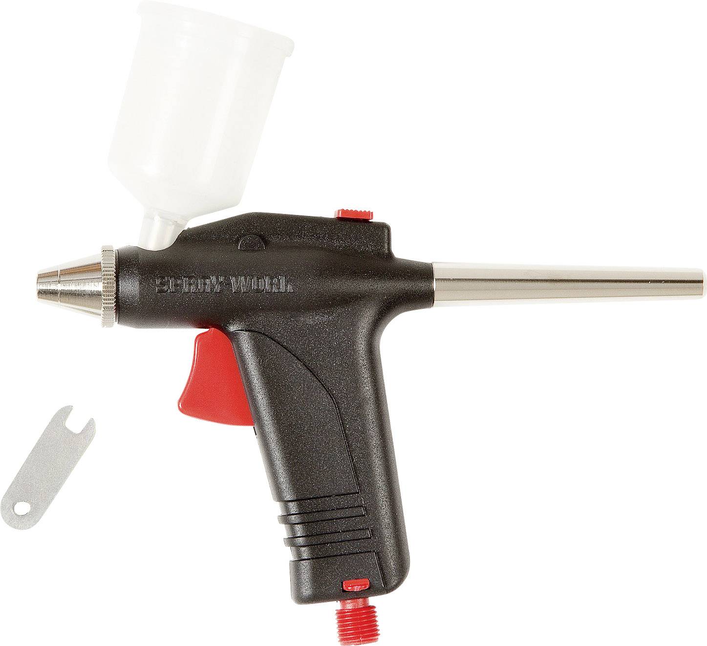 Svart airbrushpistol med vit färgtank och röd avtryckare, bredvid ett litet silververktyg.