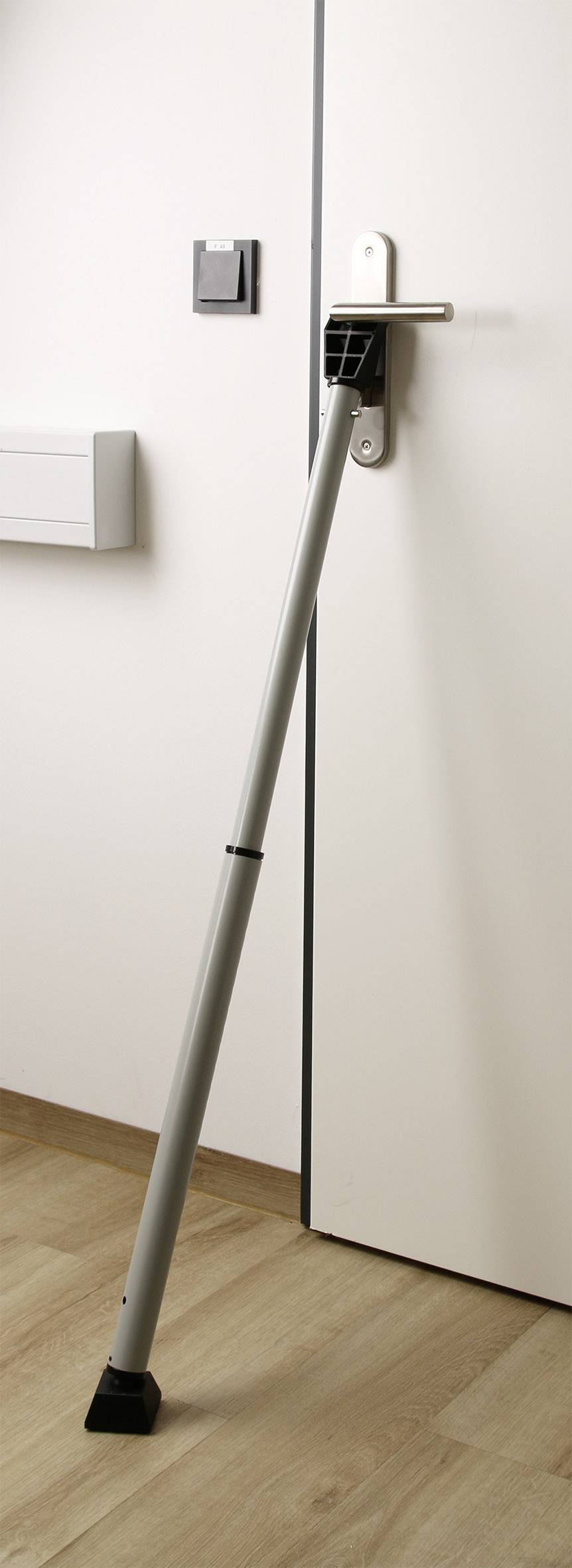 En dörrstopp säkrar en stängd dörr på ett trägolv.