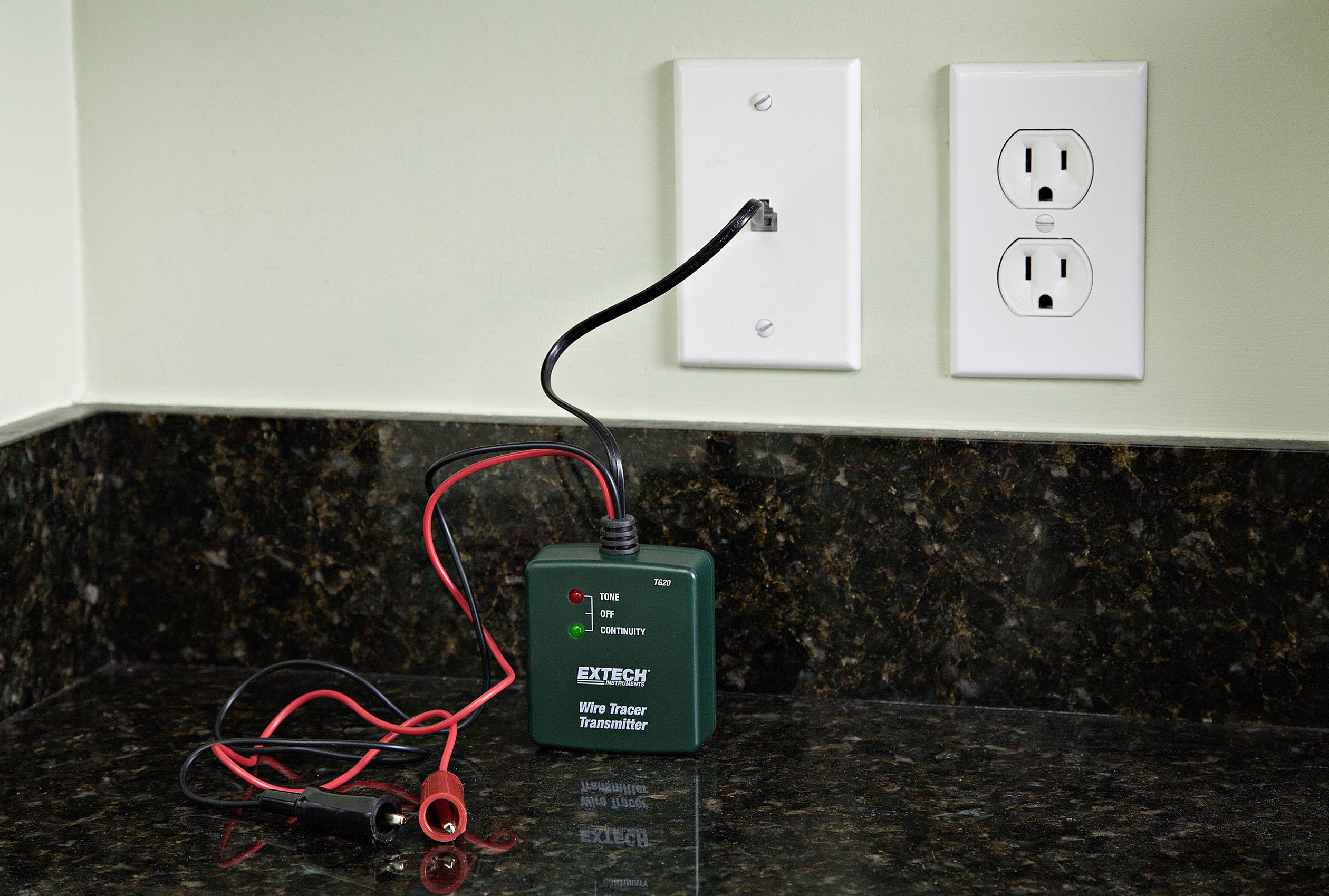 En trådmätare på en köksbänk är ansluten till ett eluttag för att testa elektriska förbindelser.