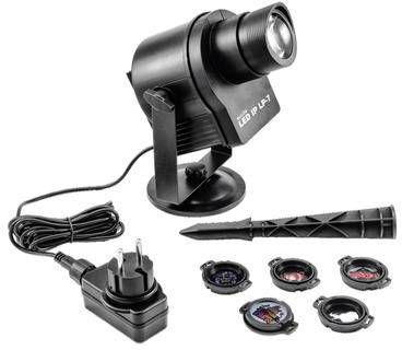 En LED-projektor med nätadapter och fyra olika objektivtillsatser för anpassning till olika bildprojektioner.