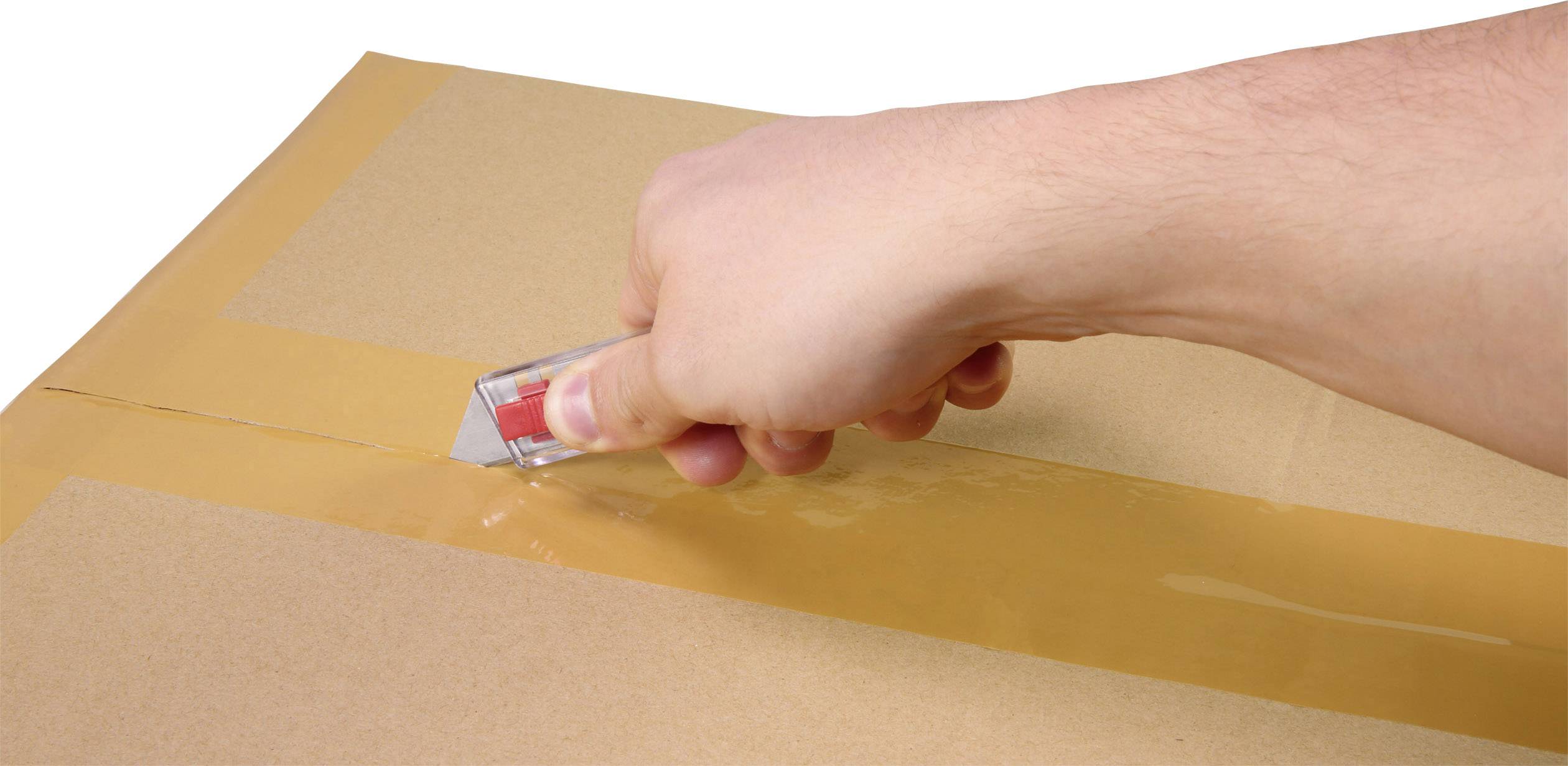 En hand använder en hobbykniv för att skära packtejp på en kartong.