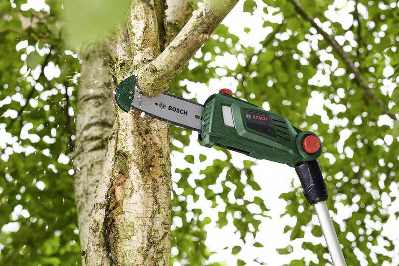 En elektrisk grensåg klipper en gren. Sågen är grön med röda knappar, monterad på en lång stång. Bosch-logotyp synlig.