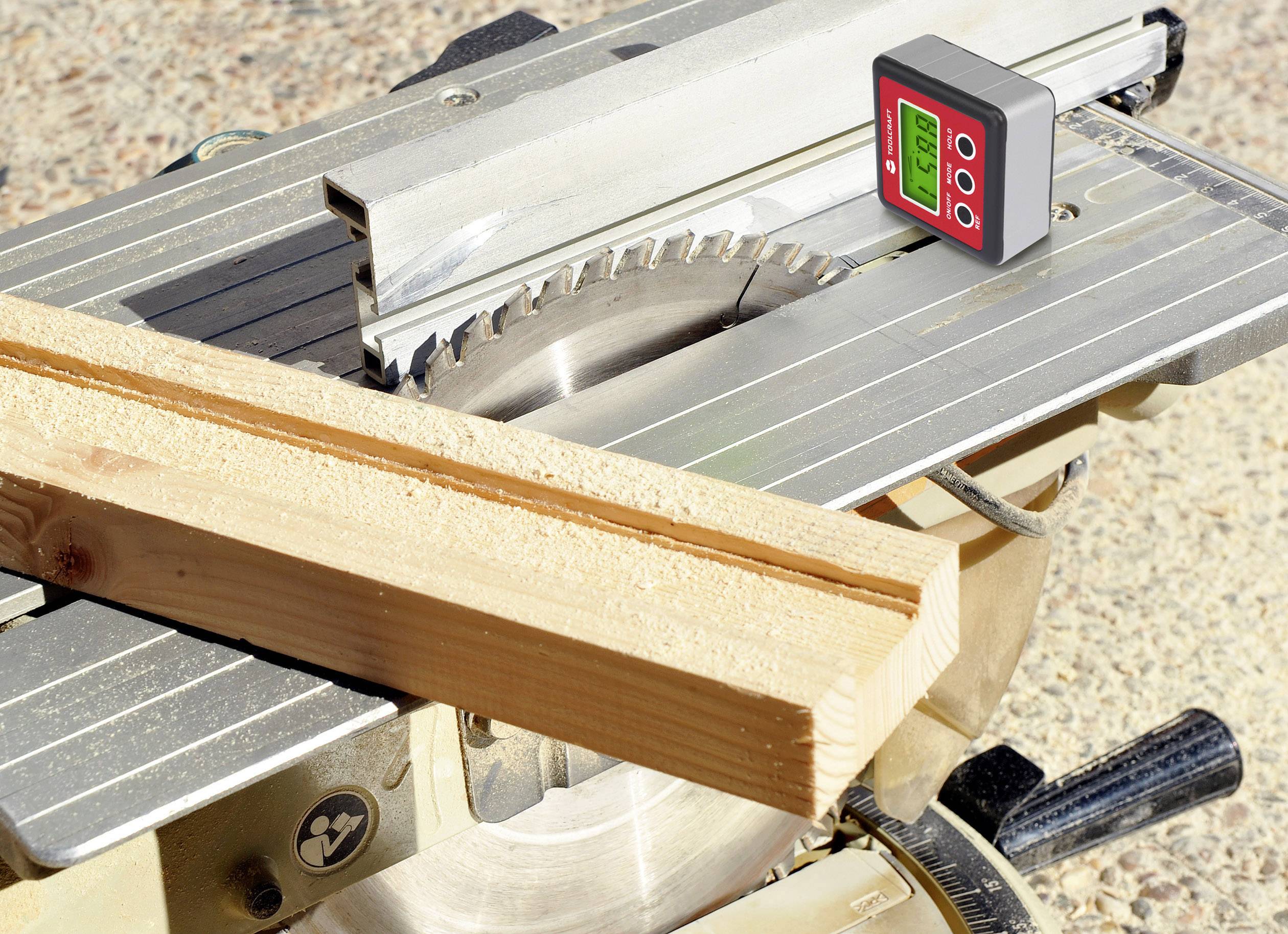 Elektrisk cirkelsåg med träbräda på bordet. En digital mätare visar vinkel.