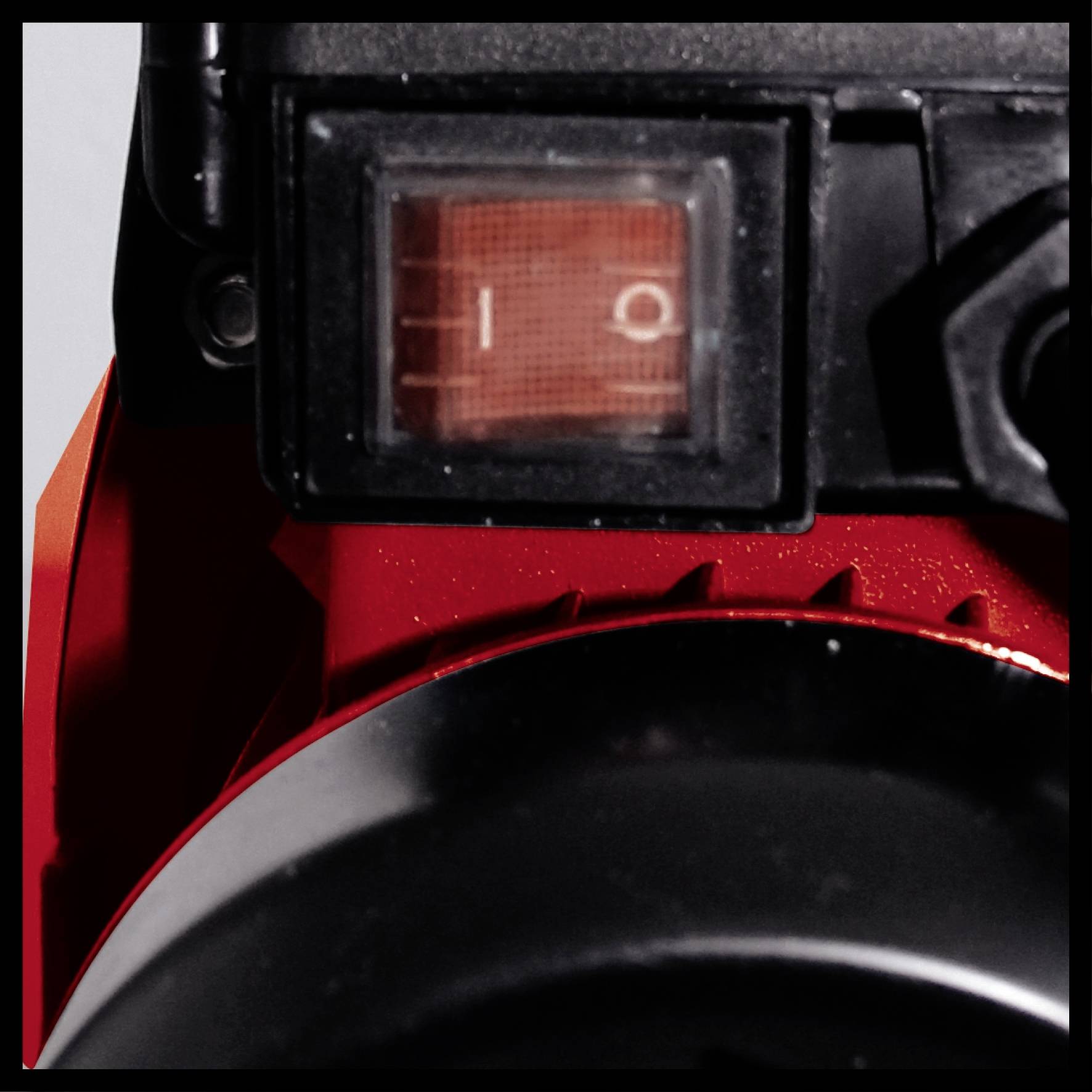 En strömbrytare med två lägen '0' och '1' på en röd apparat, sannolikt en elektronisk eller teknisk utrustning.