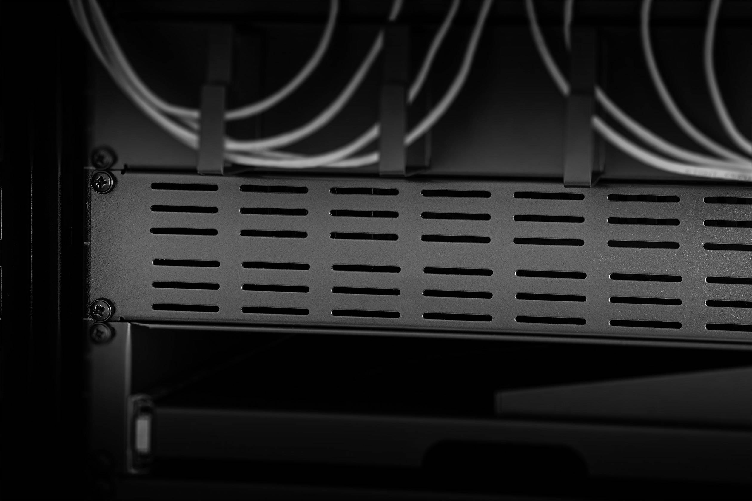Serverrack i svartvitt med flera kablar överst, visar teknisk infrastruktur i ett datacenter.