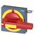 En röd nödstoppsknapp på en grå bakgrund med en gul cirkel och en klistermärke. Omkopplaren är ställd på 'På'. Varumärkets logotyp är synlig.
