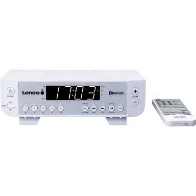 Radioväckarklocka med stor display visar '17:03'. Till vänster finns olika manöverknappar, till höger ligger en fjärrkontroll.