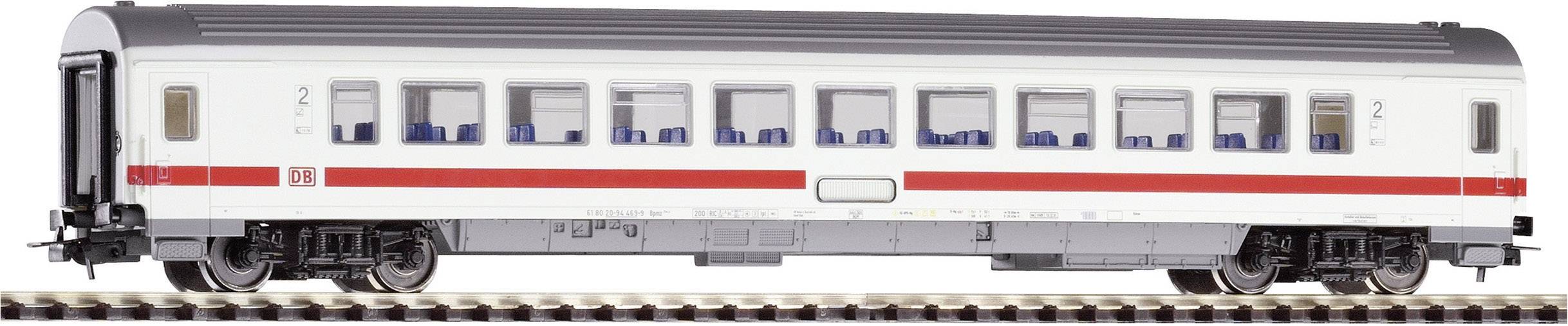 Ett vitt personståg med röd rand från Deutsche Bahn står på järnvägsspåren. Flera fönster med blå säten syns tydligt.