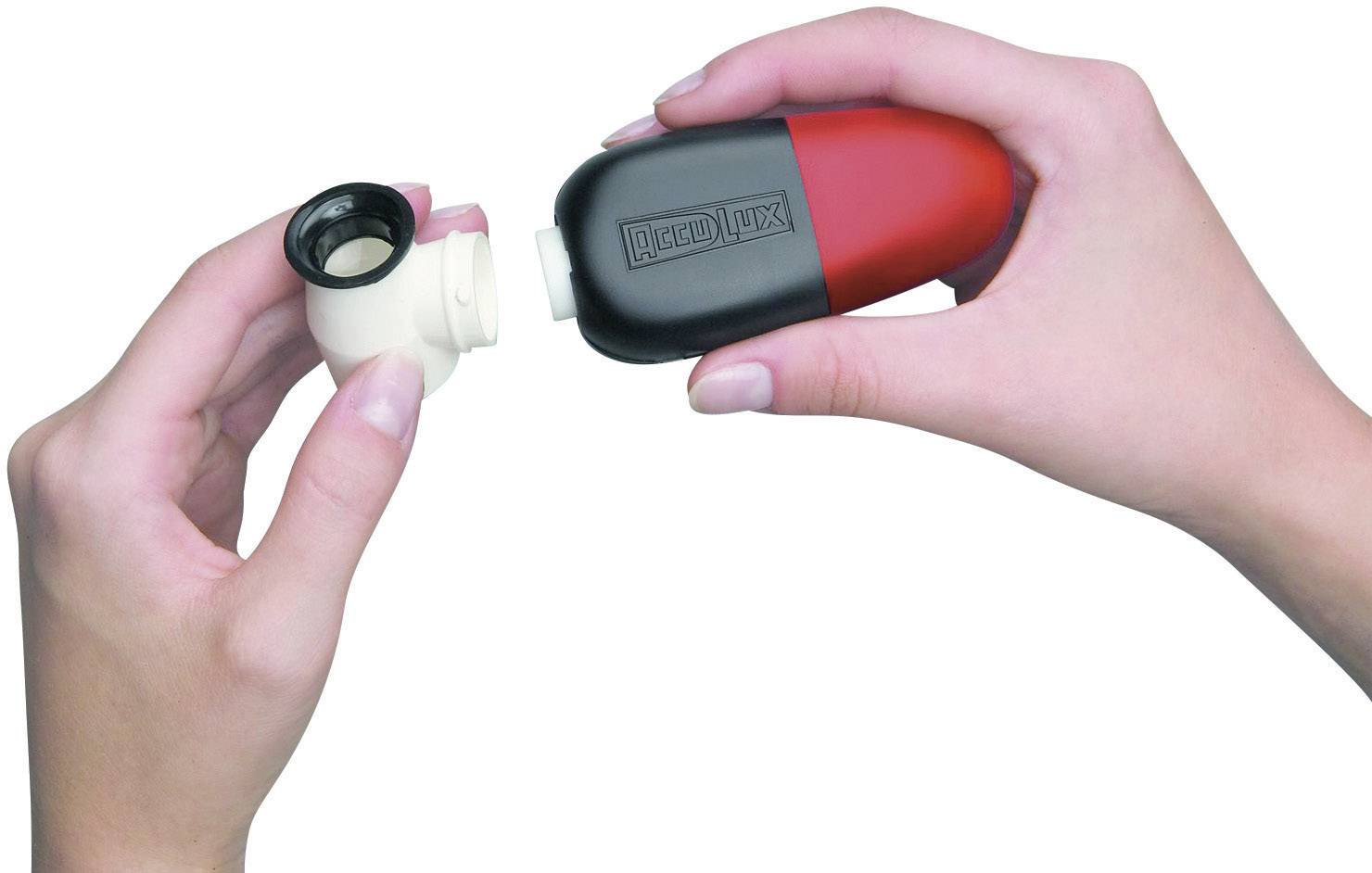 Två händer håller en röd och svart inhalationsenhet; en hand separerar munstycket och höljet.