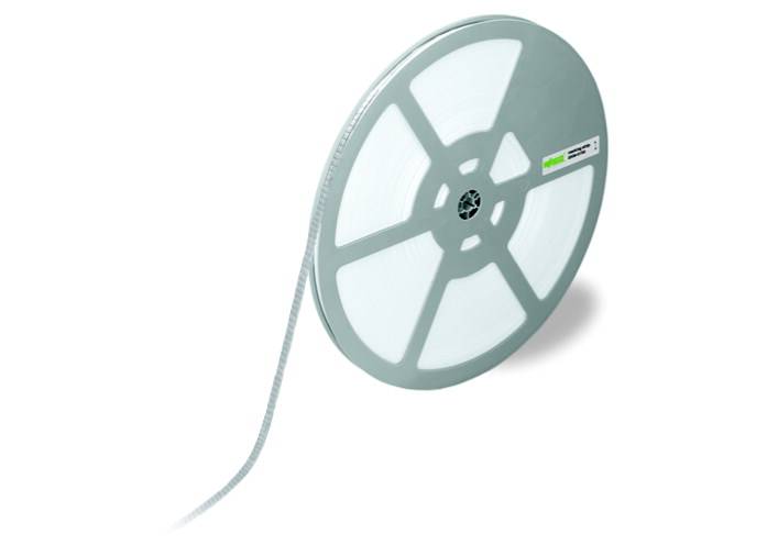 En stor rulle med ett band av vita, rektangulära etiketter. Rullen har en etikett med gröna markeringar.