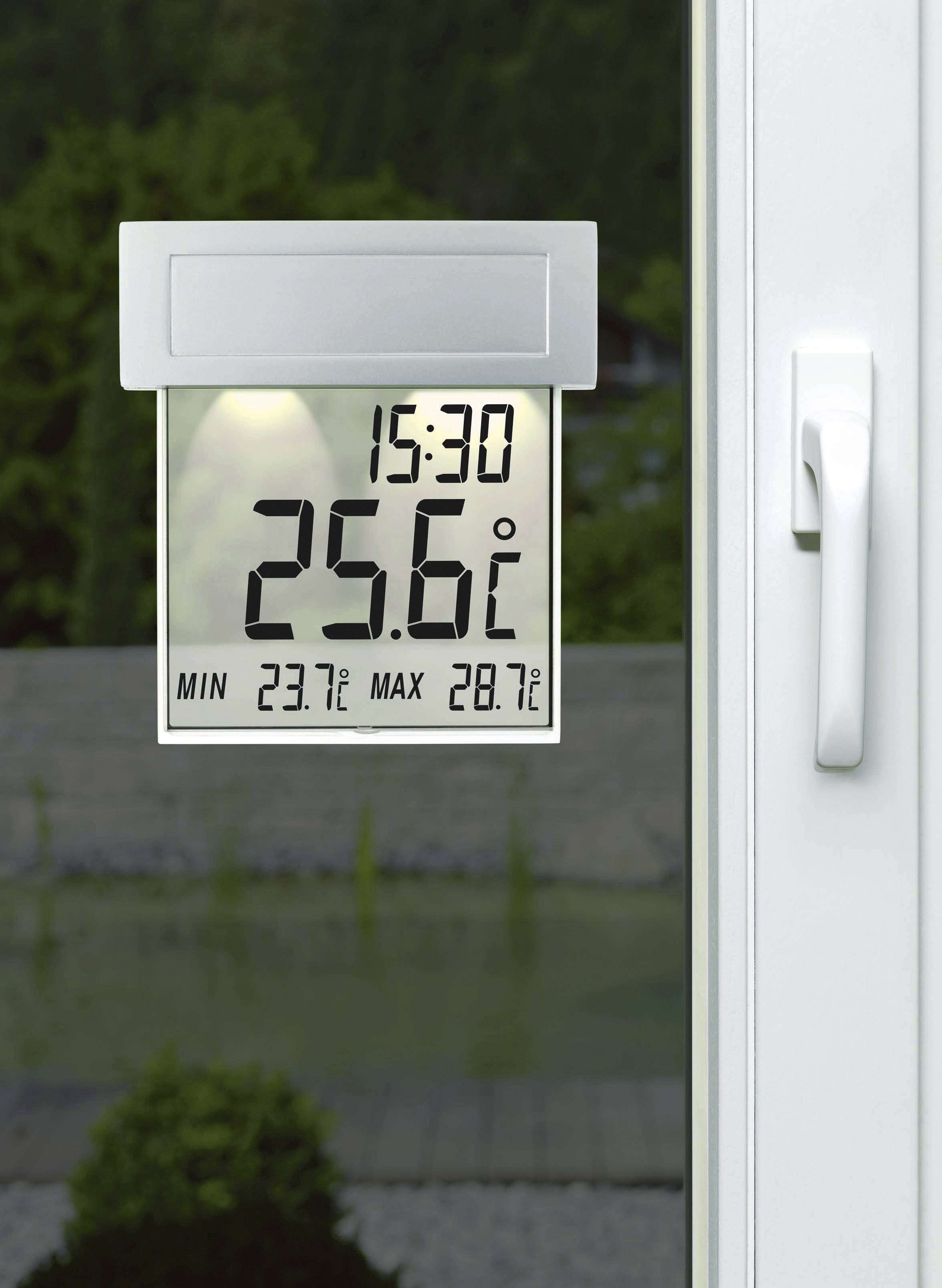 En digital termometer vid ett fönster visar 15:30 och 25,6°C, med minimivärde 23,7°C och maximivärde 28,7°C.