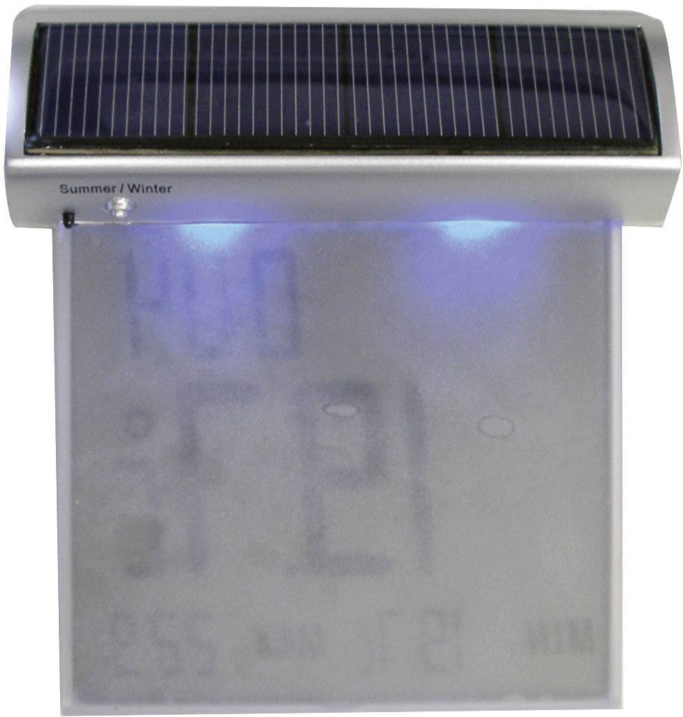 Digitalt termometer med solcell och blå belysningseffekt. Visar temperatur och tid. Överst står det 'Sommar/Vinter'.