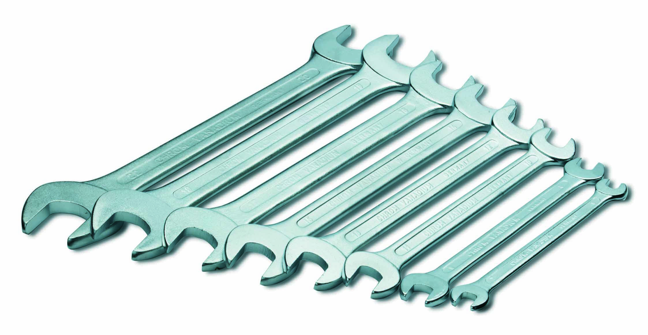 En uppsättning nio skruvnycklar i olika storlekar, arrangerade från stor till liten på en vit yta.