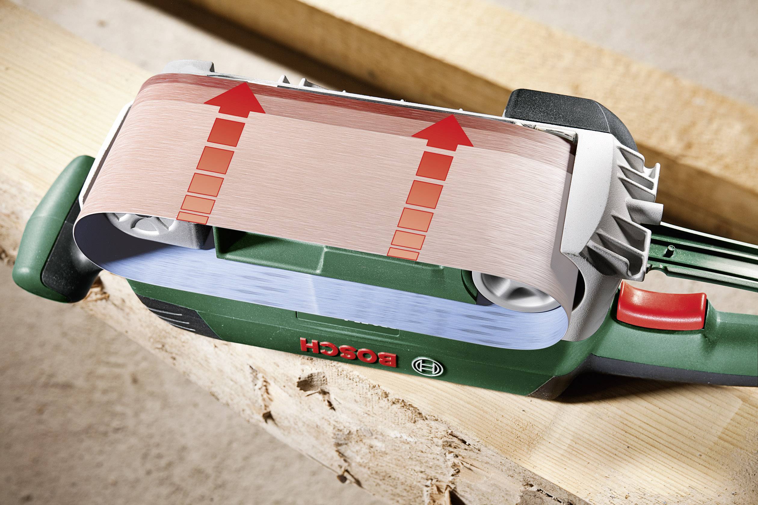 Bosch bandslipad på ett trästycke i en verkstad, där slipyteeffekten förstärks genom transparent grafik med pilar.