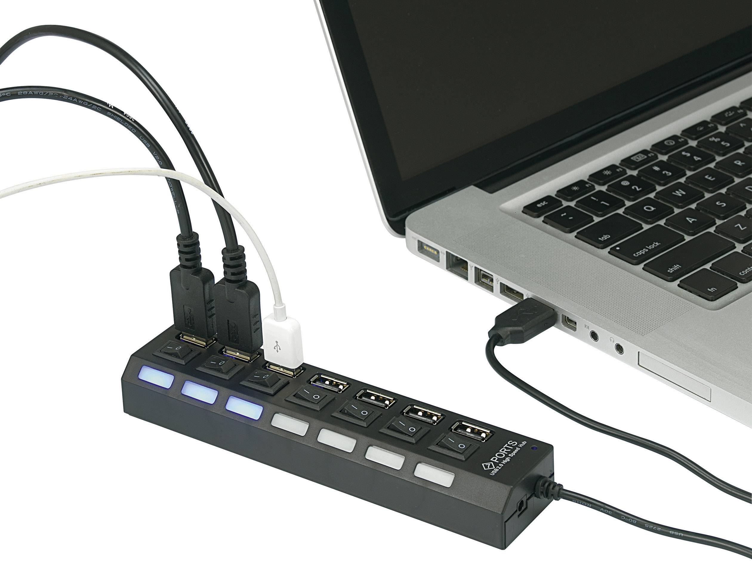 En laptop är ansluten till en USB-hubb som ansluter flera kablar. Hubben har belysta switchar för varje anslutning.