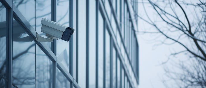 Bezpečnostní kamera na skleněné fasádě budovy.