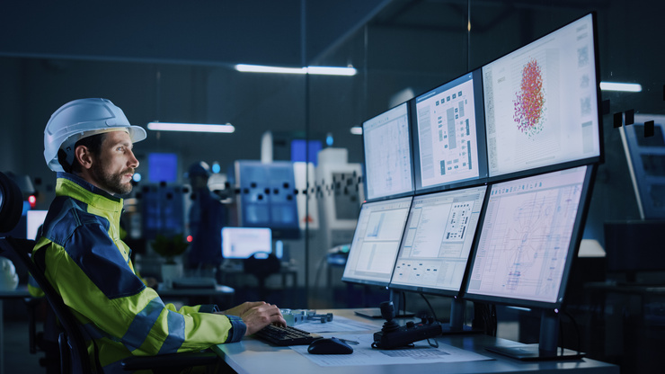 Ingenieur mit Schutzhelm überwacht Maschinendaten – Condition Monitoring