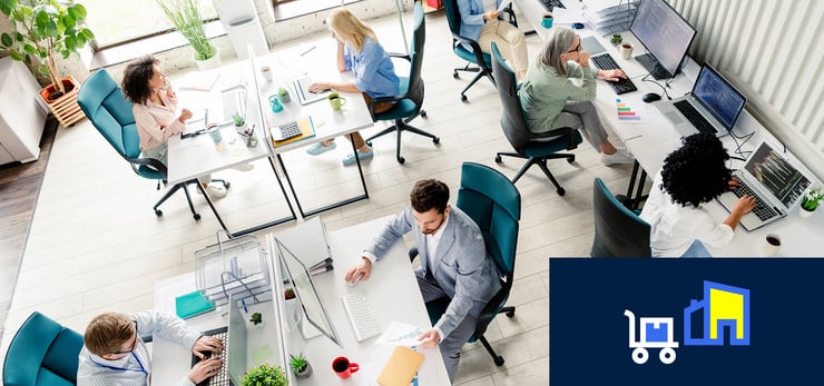 Modernes Großraumbüro mit mehreren Personen an Computerarbeitsplätzen bei der Zusammenarbeit im Büroalltag.