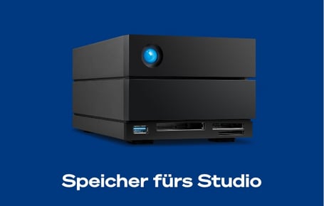 Ein tiefblauer Kasten zeigt ein großes, schwarzes LaCie-Speichersystem mit einem leuchtend blauen Kreis an der Vorderseite oben links und mehreren Anschlüssen und Kartenslots unten, darunter steht in weißer Schrift "Speicher fürs Studio".