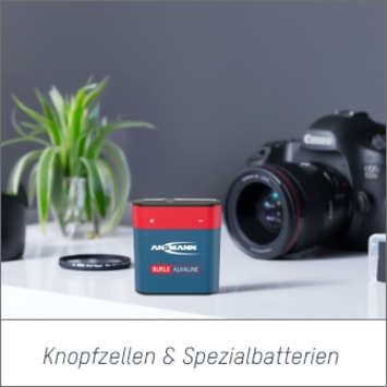 Das Bild zeigt eine Spezialbatterie auf einem Tisch. Im Hintergrund liegt eine digitale Spiegelreflexkamera. Bei Klick auf das Bild werden Ansmann Knopfzellen und Spezialbatterien aufgerufen.