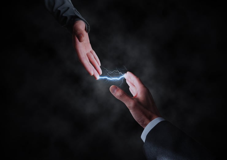 Sichtbare elektrische Ladung in Form eines Blitzes zwischen zwei Händen
