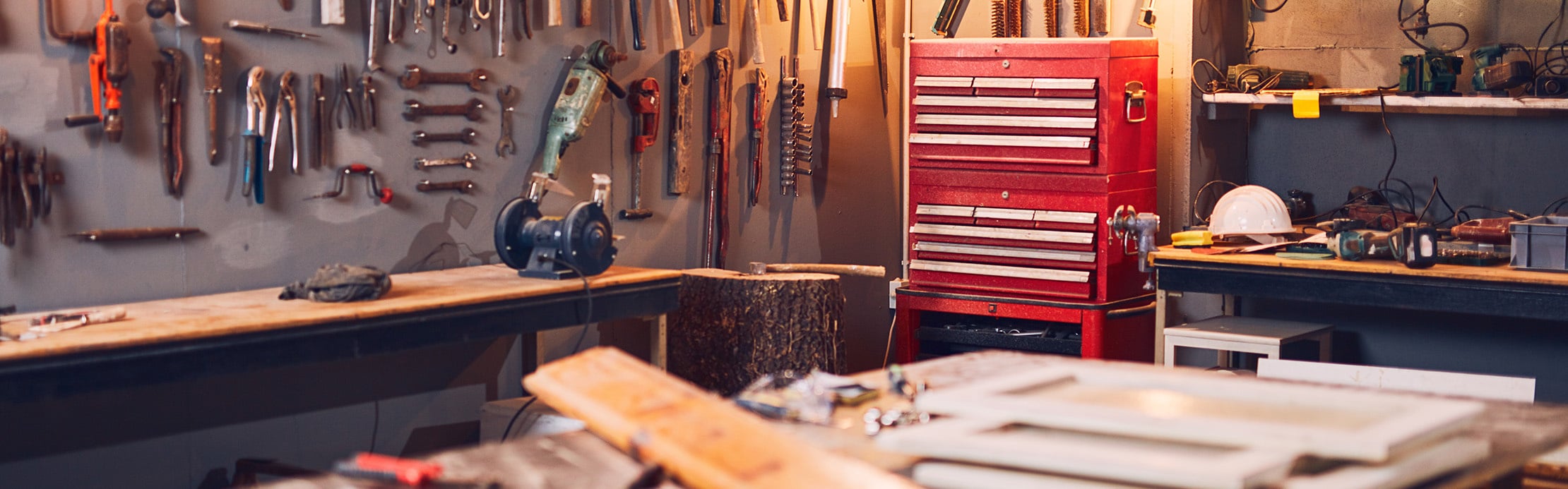 Werkstatt mit zahlreichen Werkzeugen, Werkbänken und rotem Werkzeugschrank für Reparatur- und Heimwerkerarbeiten