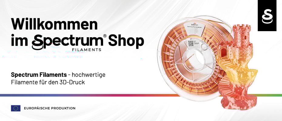 Ein Banner für den Spectrum Shop Filaments zeigt eine Spule mit regenbogenfarbenem 3D-Druck-Filament sowie ein daraus gedrucktes Modell einer Burgruine auf weißem Hintergrund mit dem Slogan „Willkommen im Spectrum Shop - hochwertige Filamente für den 3D-Druck“ und dem Hinweis auf europäische Produktion.