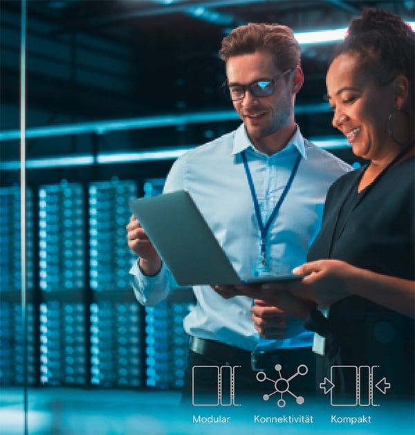 Zwei IT-Mitarbeiter überprüfen das Netz in einem Rechenzentrum auf einem Laptop.