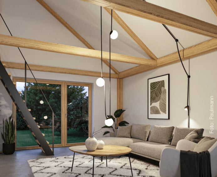 Das Bild zeigt einen nach oben offenen Wohnraum mit einer Treppe an deren Decke eine Installation von Lampen des Paulmann Gurt-Systems ULinie angebracht ist.