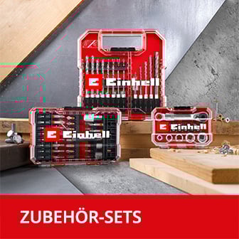 Das Bild zeigt einige Einhell Zubehörsets in Kunstoffkoffern, die auf Holzplatten arrangiert sind.