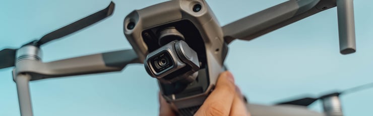 Eine Person hält eine Drohne mit Kamera in der Hand, bereit zum Abflug – Mehr erfahren zu Einsatzgebiete von Drohnen