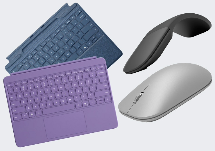Zwei Tastatur-Cover in Blau und Violett sowie eine schwarze und eine silberne Microsoft-Maus.