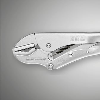 Eine Nahaufnahme zeigt eine glänzende Metall-Griffzange der Marke Knipex mit gezahnten Backen.  