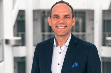 CEO Ralf Bühler im Hintergrund ist eine obere Etage des Empfangsbereiches im Conrad Firmengebäude in Hirschau.
