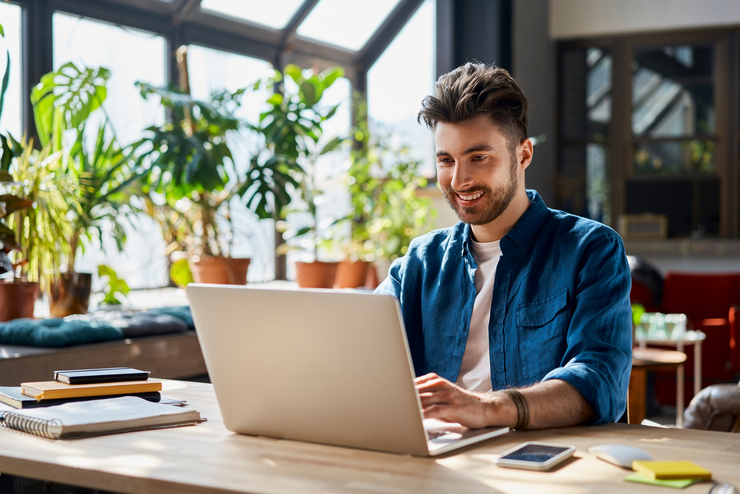 Mann arbeitet von Zuhause aus am Laptop - Hybrid Work