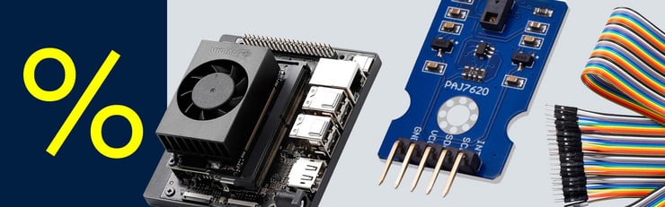 Gelbes Prozentzeichen neben einem NVIDIA-Entwicklerboard mit Lüfter, einem blauen Sensormodul und bunten Jumperkabeln.